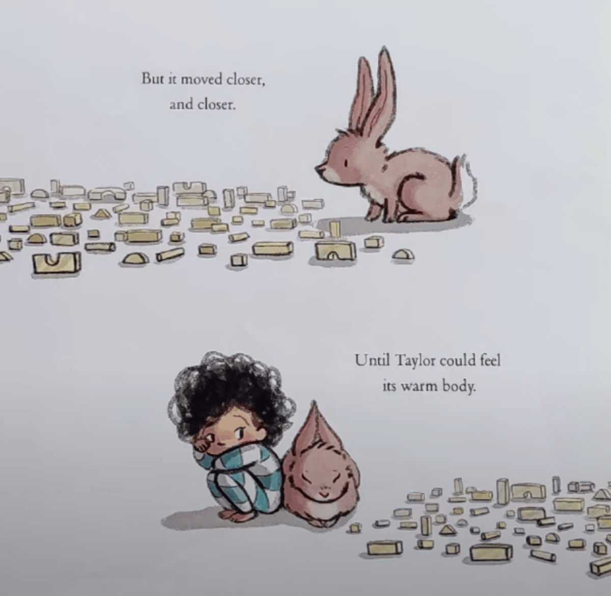 An illustration from <em>The Rabbit Listened</em> (2018) that shows two scenes. In the top half, a small brown rabbit approaches a scattered pile of yellow toy blocks. The text reads: "But it moved closer, and closer." In the bottom half, a child named Taylor with curly dark hair, wearing teal striped pajamas, sits curled up on the ground looking sad. The rabbit now sits quietly beside Taylor, leaning in. The text beside them reads: "Until Taylor could feel its warm body."