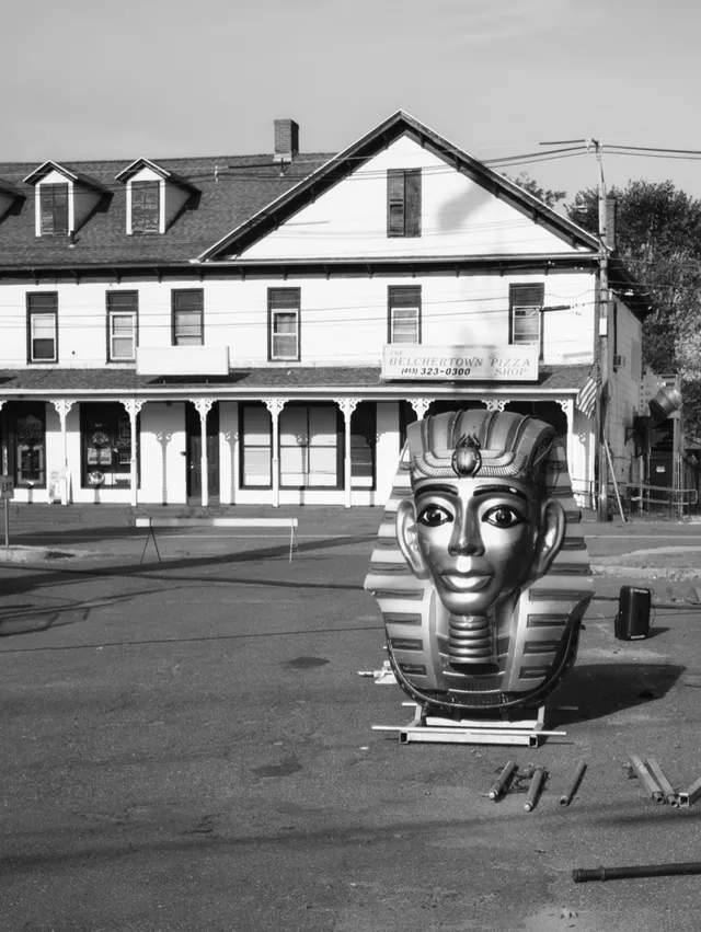 photograph of pharoah head, part of an amusement ride, in a parking lot