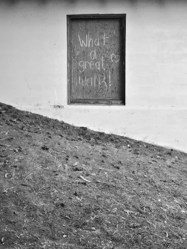 photograph of a boarded up window that says What a great walk!